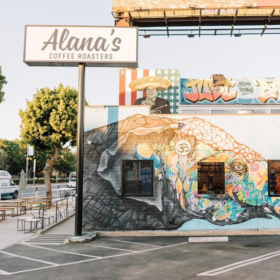 Mural on a building with 'Alana's Coffee Roasters' sign in the foreground