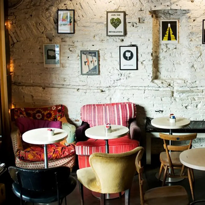 Cozy cafe interior at Barnum Coffee in Rome, Italy with colorful chairs and tables against a textured wall.