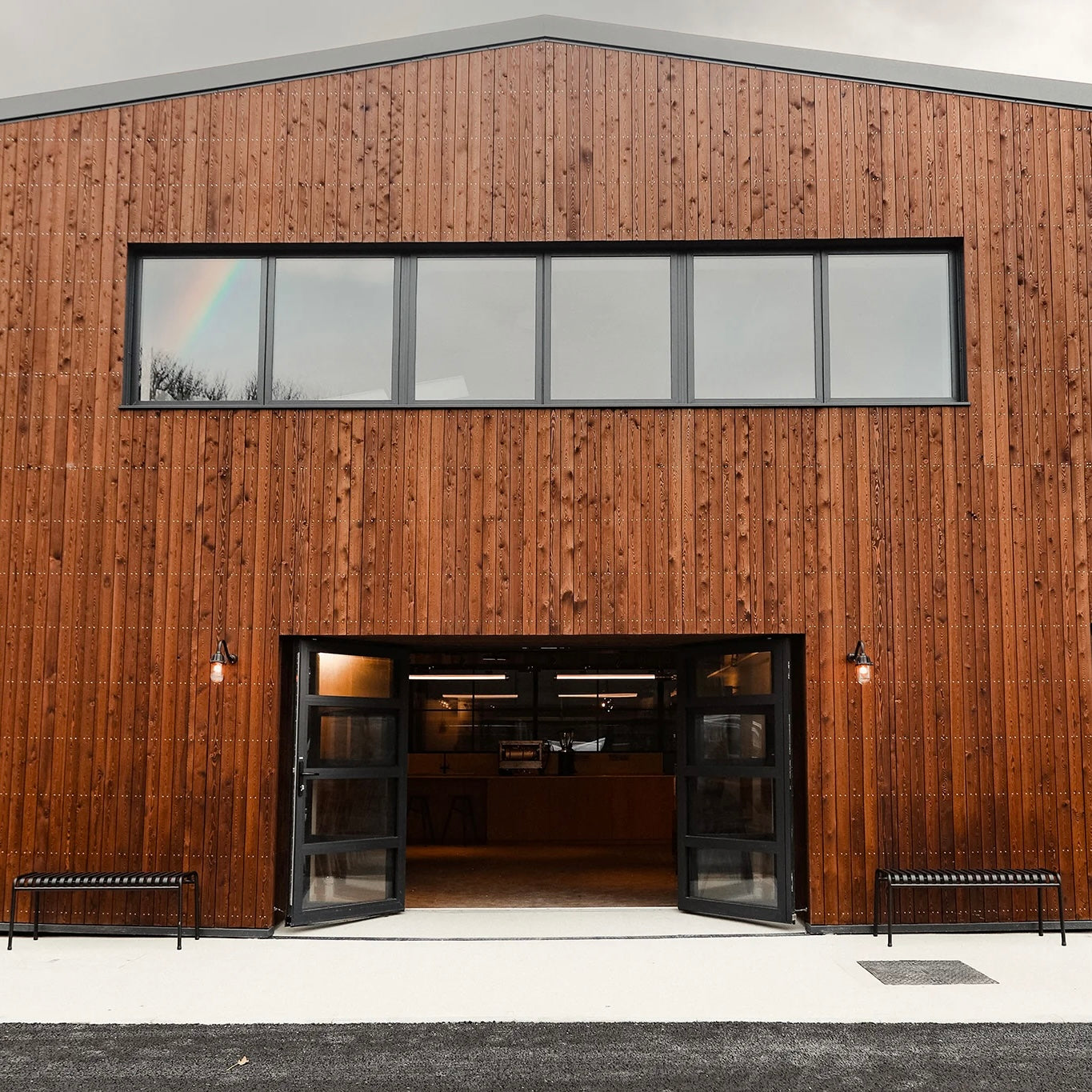 Modern third wave coffee roastery with wooden facade and glass doors