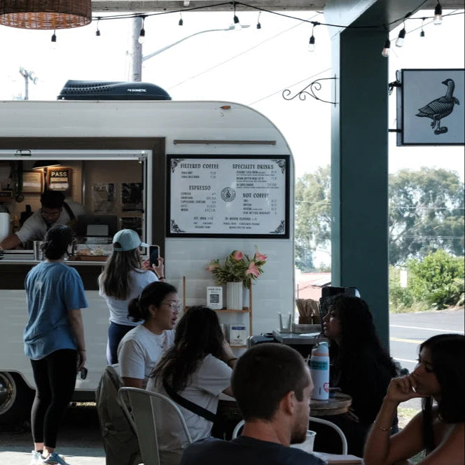 White third wave coffee truck with people around it, Hawaii